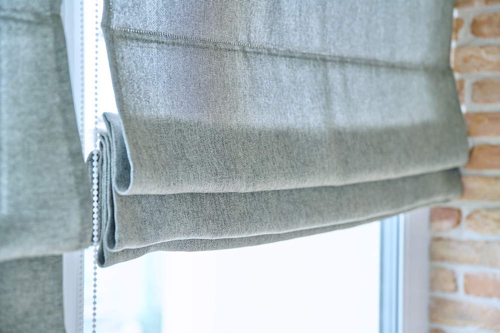 Close-up of roman blinds with gray linen fabric